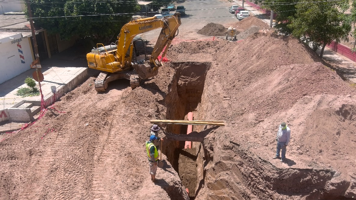 Obra de infraestructura con excavadora y zanja profunda